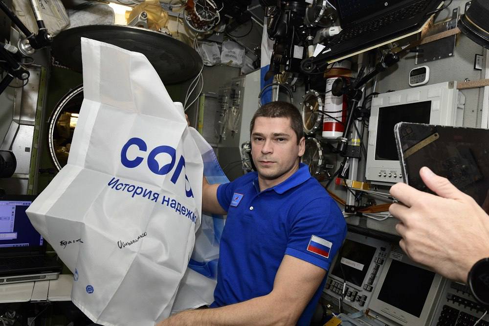 Космонавт с флагом СОГАЗа на борту МКС